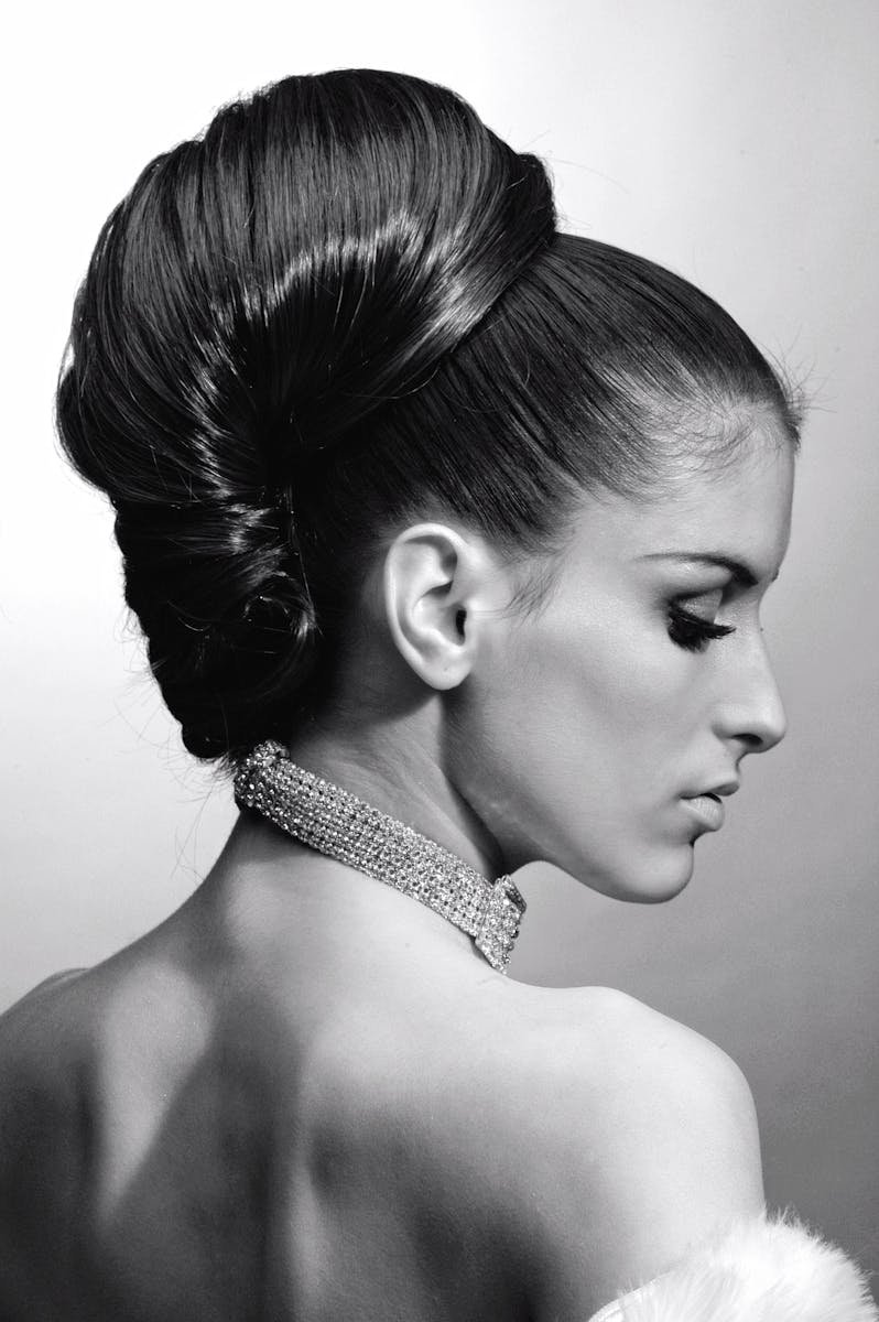 Photo by Pixabay Graceful profile portrait of a woman with elegant hairstyle and necklace.