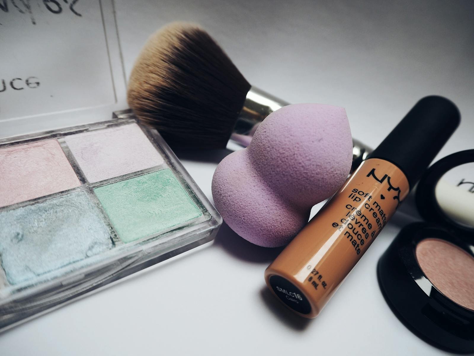 Photo by Beata Dudová A flat lay showcasing various makeup essentials including brushes, sponges, and cosmetics.