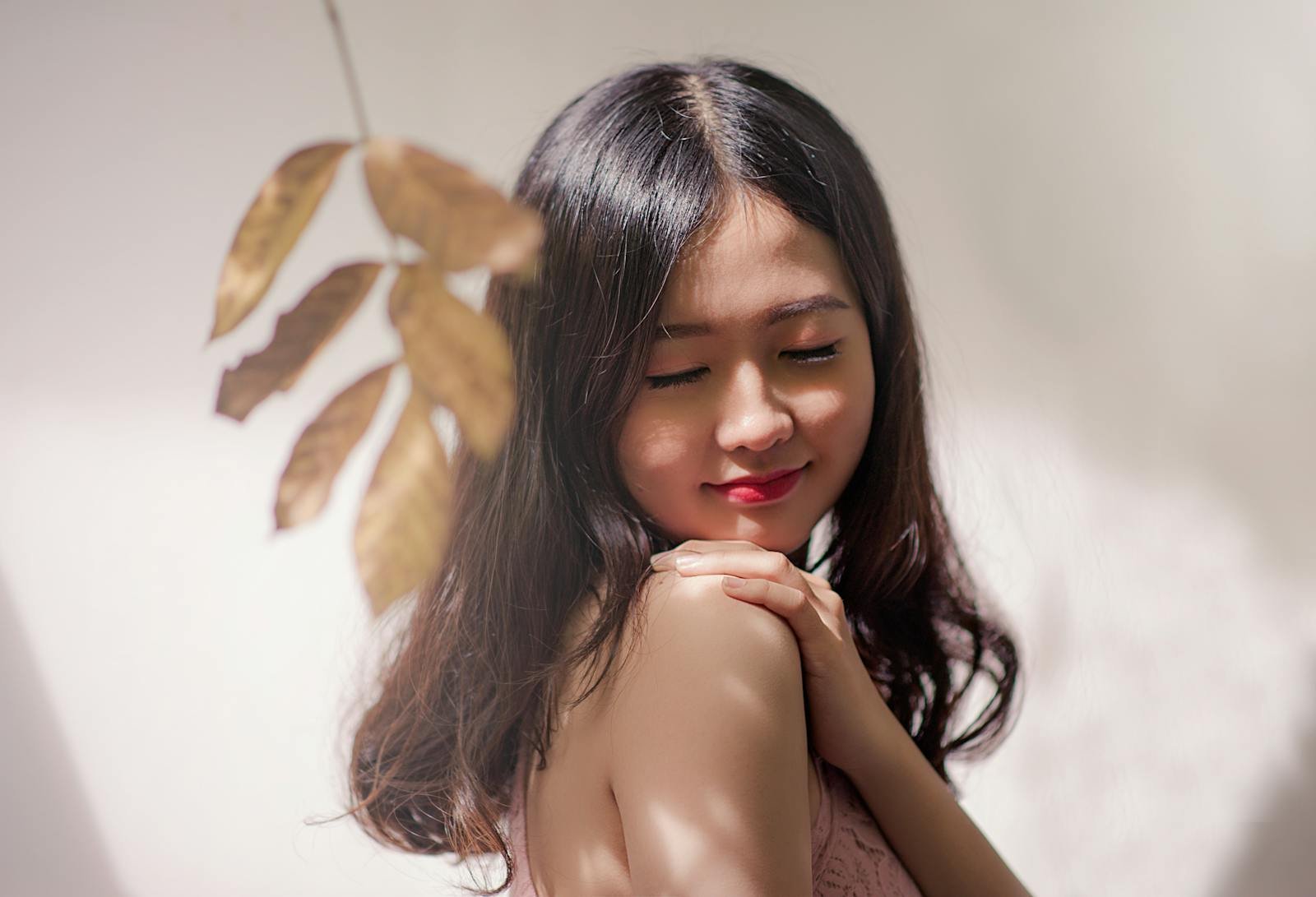 Photo by Min An Peaceful young woman with eyes closed, embracing serenity with a gentle smile.